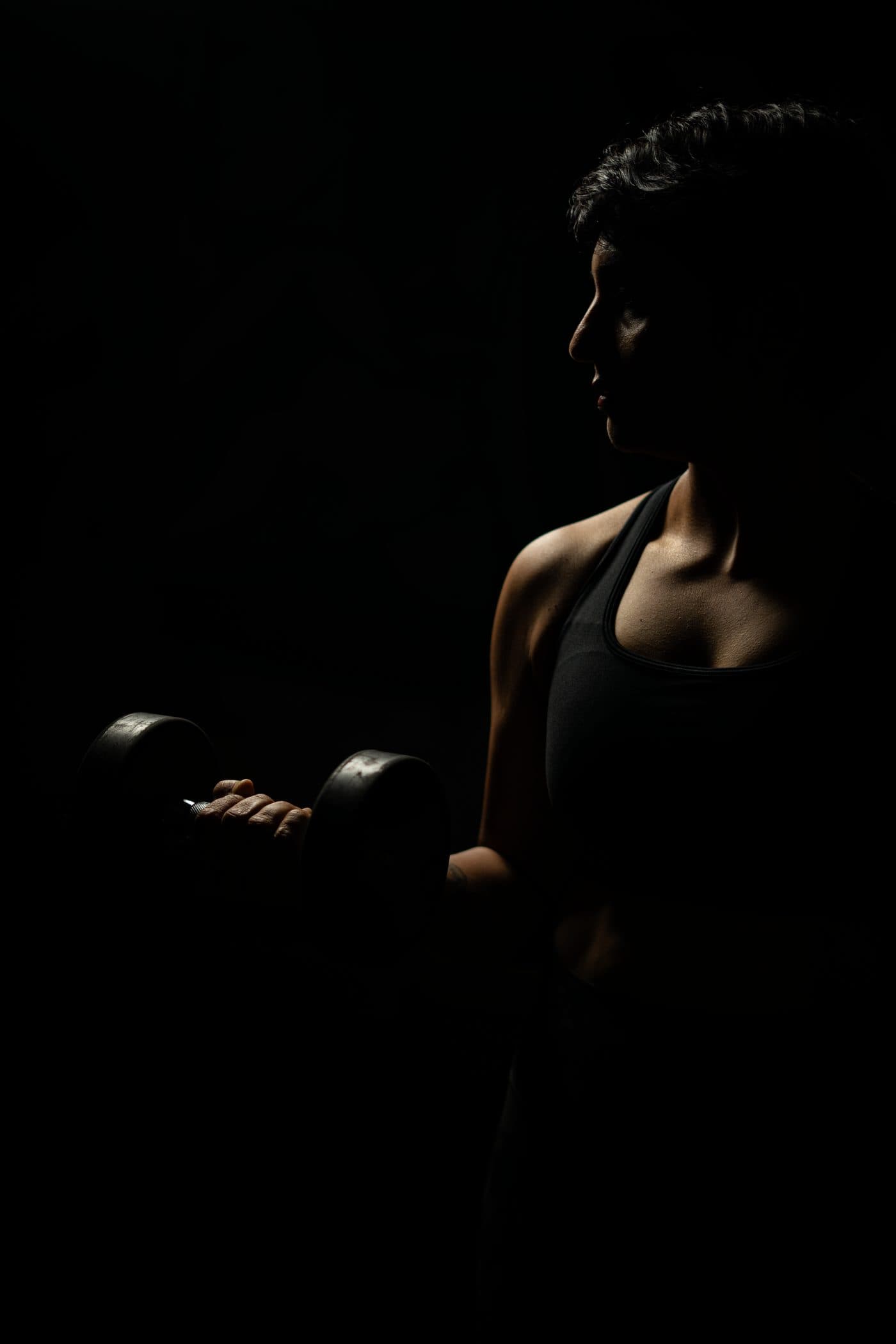Woman strength training in a gym as part of the MenoThrive coaching approach